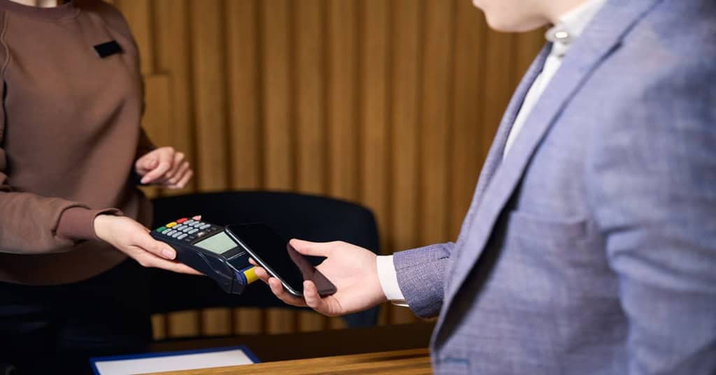 iPhoneを使って決済をするスーツ姿の男性